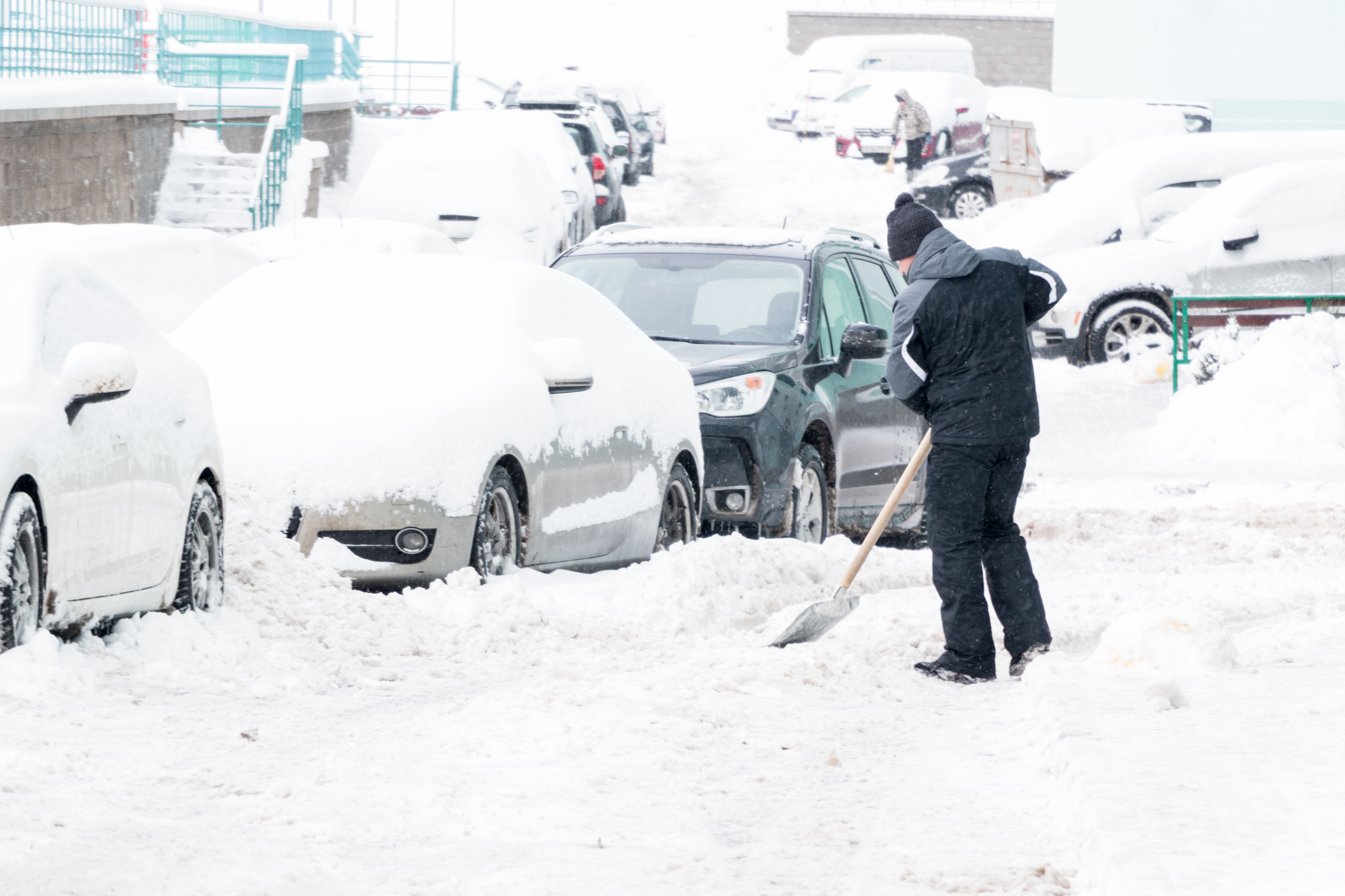 man removes snow in the yard